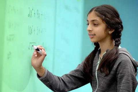 List of Math Formulas | HeLovesMath Young girl writing algebra formulas on a classroom whiteboard, solving equations for math practice on helovesmath.com